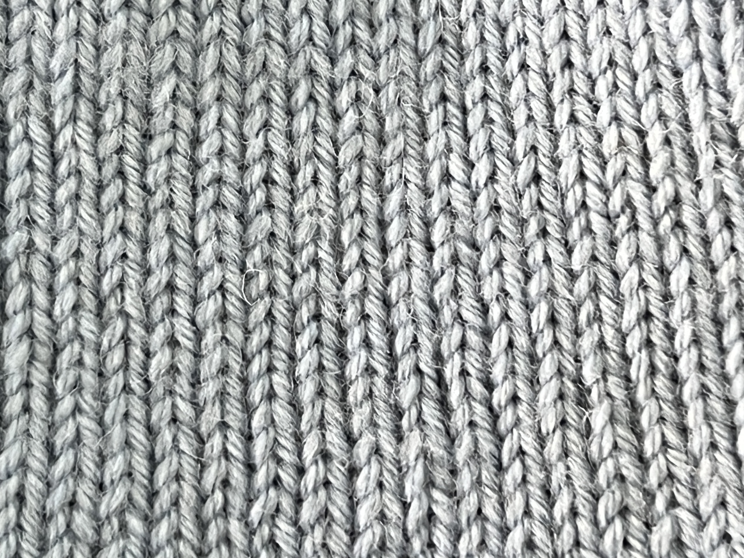 Close view of stockinette fabric showing repeated V-shaped knitted stitches